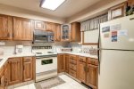 Full kitchen with dishwasher, microwave, coffee maker, cookware, and utensils